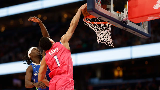Washington Wizards guard Johnny Davis (1) dunks on Milwaukee Bucks guard Jrue Holiday.